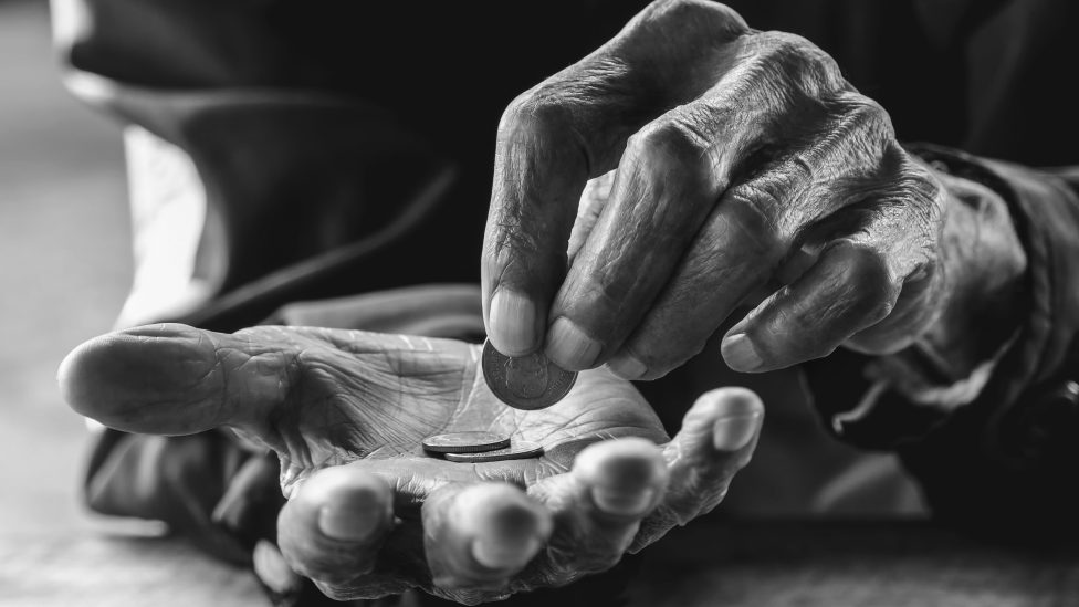 hand old man begging for money because of the hunger on the wood table. vintage tone